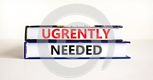 Urgently needed symbol. Concept words Urgently needed on books on a beautiful white table white background. Business and urgently