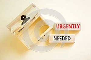 Urgently needed symbol. Concept words Urgently needed on wooden blocks on a beautiful white table white background. Empty wooden