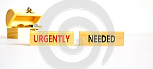 Urgently needed symbol. Concept words Urgently needed on wooden blocks on a beautiful white table white background. Wooden chest