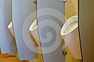 Urinals behind partitions photo