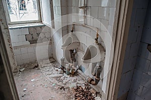 Urinals at the rest room in the abandoned ruined building located in the Chernobyl ghost town