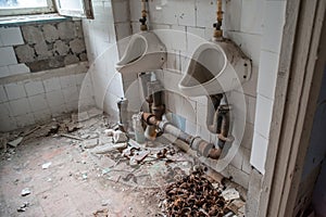 Urinals at the wash room in the abandoned ruined building located in the Chernobyl ghost town