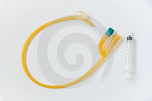 Foley catheter and syringe on white background