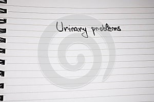 Urinary problems handwriting  text on paper, on office agenda. Copy space