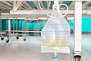 Urine bag hanging beside the patient`s bed. Inside the hospital