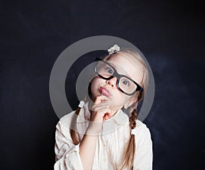 Ð¡urious child thinking. Funny little girl in glasses