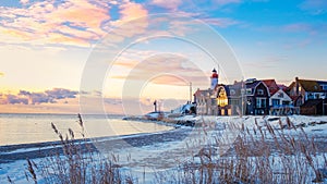 Urk Netherlands lighthouse during winter with snow covered coastline, Urk view at the lighthouse snowy landscape winter