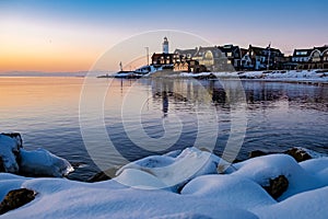 Urk Netherlands lighthouse during winter with snow covered coastline, Urk view at the lighthouse snowy landscape winter