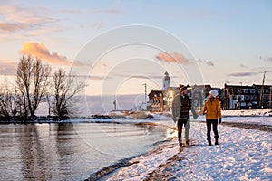 Urk Netherlands lighthouse during winter with snow covered coastline, Urk view at the lighthouse snowy landscape winter