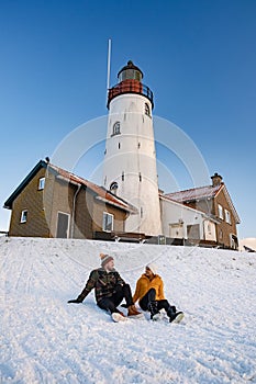 Urk Netherlands lighthouse during winter with snow covered coastline, Urk view at the lighthouse snowy landscape winter