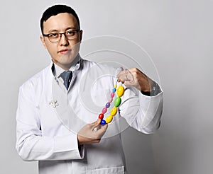 Urology proctology concept. Man doctor urologist or proctologist in white medical gown holds shows male testicles tool photo