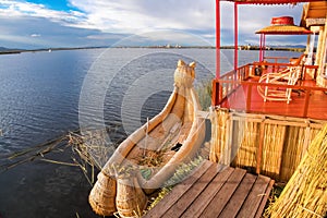 Uros floating island and Totora traditional boat on Titicaca lake, Puno city, Peru