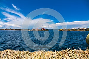 Uros floating island and Totora traditional boat on Titicaca lake, Puno city, Peru