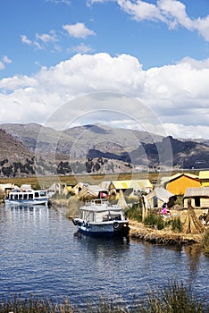 Uros, Peru - Jan 5, 2019. Traditional Totora boat with tourists on Titicaca lake near to the Uros floating islands , Puno, Peru,