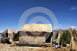 Uros, Peru - Traditional Totora boat with tourists on Titicaca lake near to the Uros floating islands , Puno, Peru, South America.