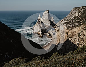 Ursa Beach Sea stack, Portugal. Atlantic Ocean Foamy waves rolling to rocks. Holiday vacation landscape scene