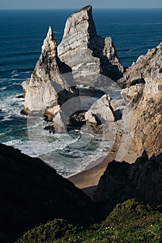 Ursa Beach Sea stack, Portugal. Atlantic Ocean Foamy waves rolling to rocks. Holiday vacation landscape scene