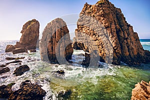 Ursa beach, Sintra, Portugal. Epic sea stack rocks rising from atlantic ocean in sunset light