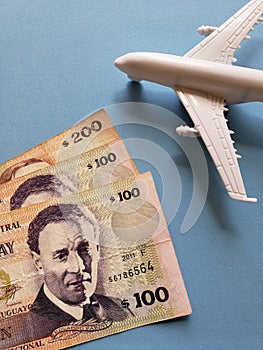 uruguayan banknotes, white plastic airplane and blue background