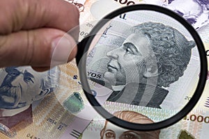 Uruguayan money in a magnifying glass