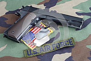 US AIR FORCE branch tape , M1911 handgun with dog tags on woodland camouflage uniform