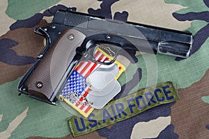 US AIR FORCE branch tape , M1911 handgun with dog tags on woodland camouflage uniform