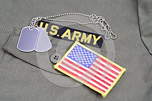 US ARMY Branch Of Service Tape with dog tags and flag patch on olive green uniform