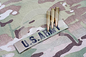 US ARMY branch tape and 5.56 mm rounds on camouflage uniform