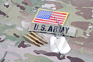 US ARMY branch tape with dog tag flag patch and 5.56 mm rounds on camouflage uniform