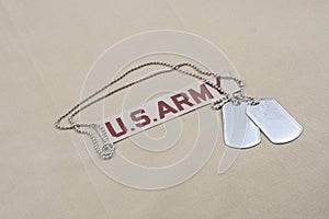 US ARMY branch tape with dog tags on desert camouflage uniform