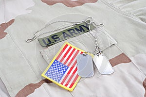 US ARMY branch tape with dog tags and flag patch on desert camouflage uniform