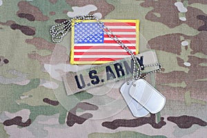 US ARMY branch tape with flag patch and dog tag on camouflage uniform