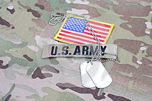 US ARMY branch tape with flag patch and dog tag on camouflage uniform