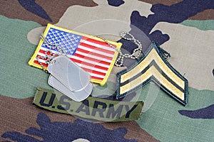 US ARMY Corporal rank patch, branch tape, flag patch and dog tags on woodland camouflage uniform