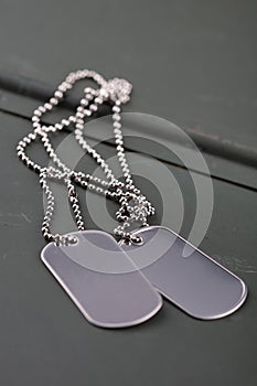 US army dog tags on green ammo can