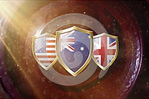 Us Australia and Great Britain flags in golden shield on copper texture background.aukus defense pact