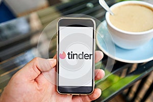 US, California - June 23 2023: Tinder logo. Dating app in mobile phone screen. Man swiping and liking profiles on