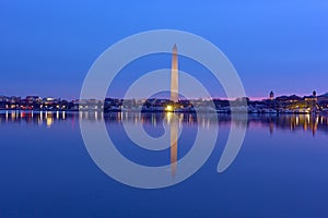 US capital panorama along Tidal Basin reservoir during cherry blossom at dawn.