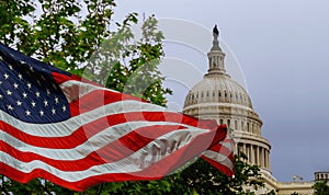 The US Capitol building with a waving American flag superimposed on the sky photo