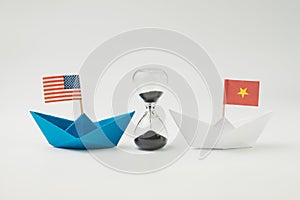 US and China financial trade war tariff strategy concept, hourglass / sandglass at the center between blue paper ship with