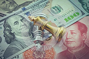 The US and China trade war and currency war concept. Two king chess piece fight on US dollar and Chinese yuan renminbi banknotes