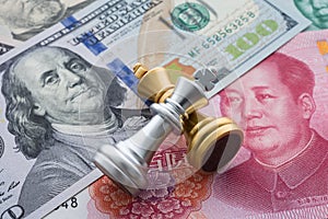 The US and China trade war and currency war concept. Two king chess piece fight on US dollar and Chinese yuan renminbi banknotes