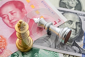 The US and China trade war and currency war concept. Two king chess piece fight on US dollar and Chinese yuan renminbi banknotes