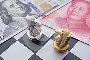 US and China trade war and currency war concept. Two knights chess face to face on chessboard, US dollar and Chinese yuan renminbi