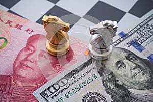 US and China trade war and currency war concept. Two knights chess face to face on chessboard, US dollar and Chinese yuan renminbi