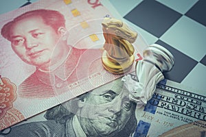 US and China trade war and currency war concept. Two knights chess face to face on chessboard, US dollar and Chinese yuan renminbi