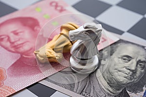 US and China trade war and currency war concept. Two knights chess fight on chessboard, US dollar and Chinese yuan renminbi