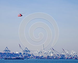 US Coast Guard helicopter flying over shipyards