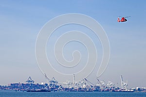US Coast Guard helicopter flying over shipyards in New York Harbor