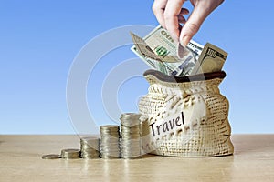 US dollar bills in Bag with coins Stack on table, blur background. Concept of money saving on travel